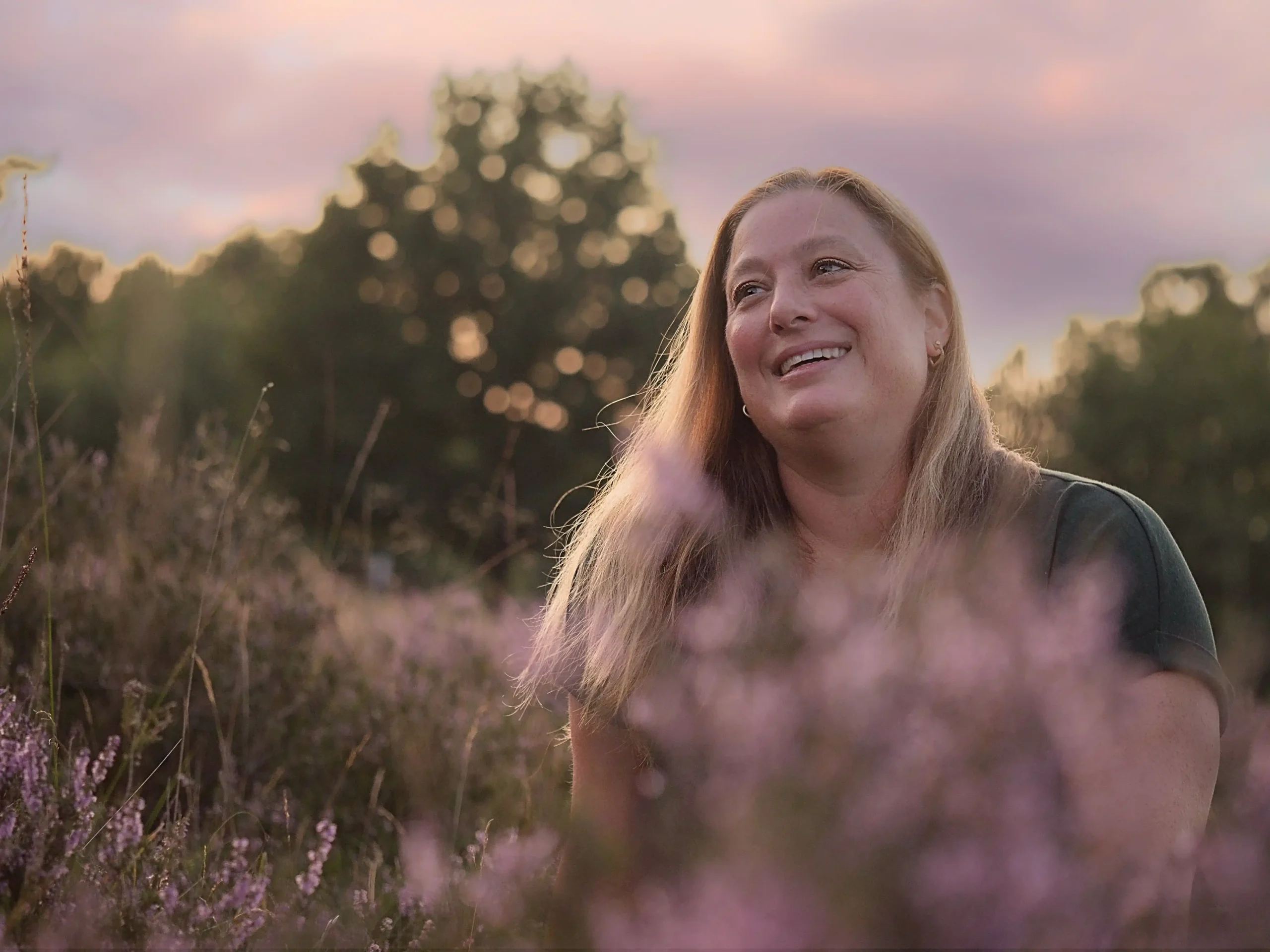 Vrouw tussen de paarse heide onzekerheid en toch stralen, natuurlijk licht fotografie Eveline, Schoonhoven